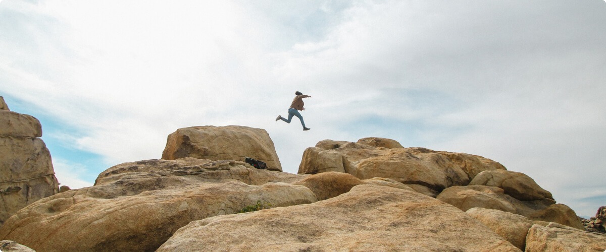 Person jumping on rocks