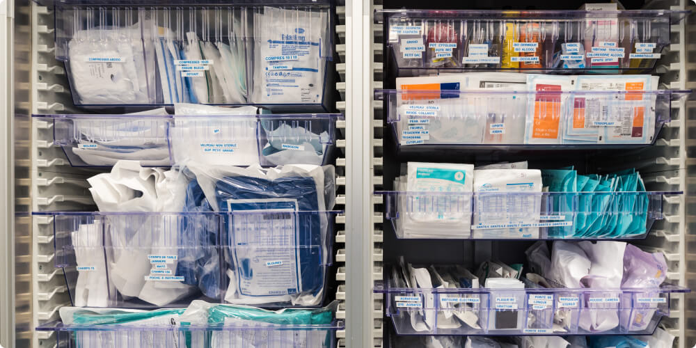 Organized hospital supply cabinet with labeled bins of medical supplies